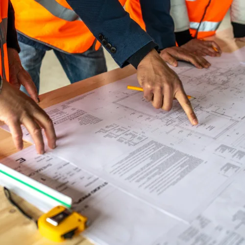 Construction team reviewing blueprints for a commercial project